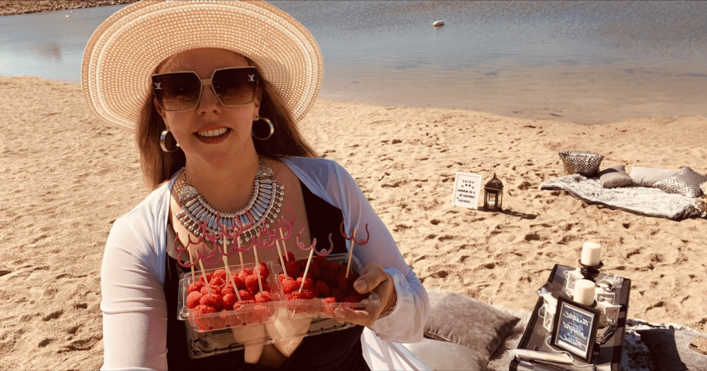 Image of a woman eating fruit on a beach celebrating being breast cancer free