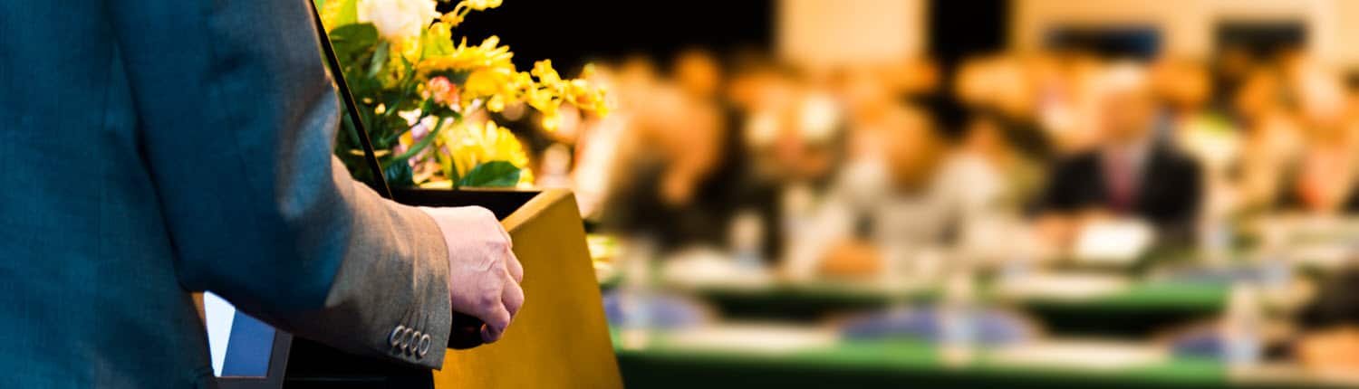 Man speaking in front of conference attendees