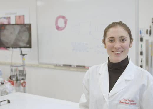 Female Merit engineer standing in front of a white board and an ultrasound monitor