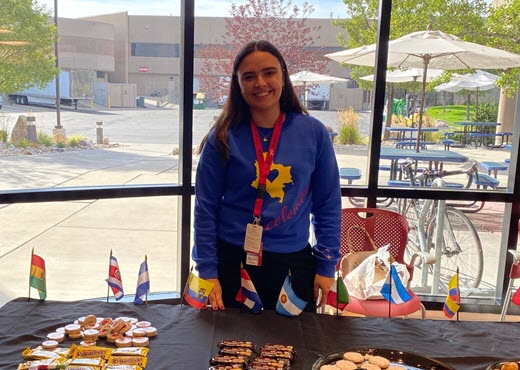 Daniela stands i front of a table of hispanic treats for Hispanic Heritage Month