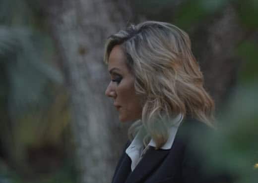 Image shows Tara Zuzga walking thru forest, shown in silhouette