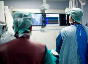 Cardiologists are in a angio operation, following the LCD screens for the stent