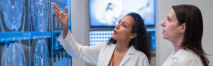 Two female doctors looking at and discussing MRIs