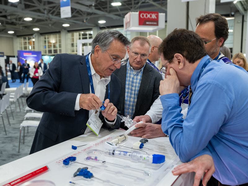 Bob Poser demonstrating spine products at the Merit Medical booth at SIR 2024