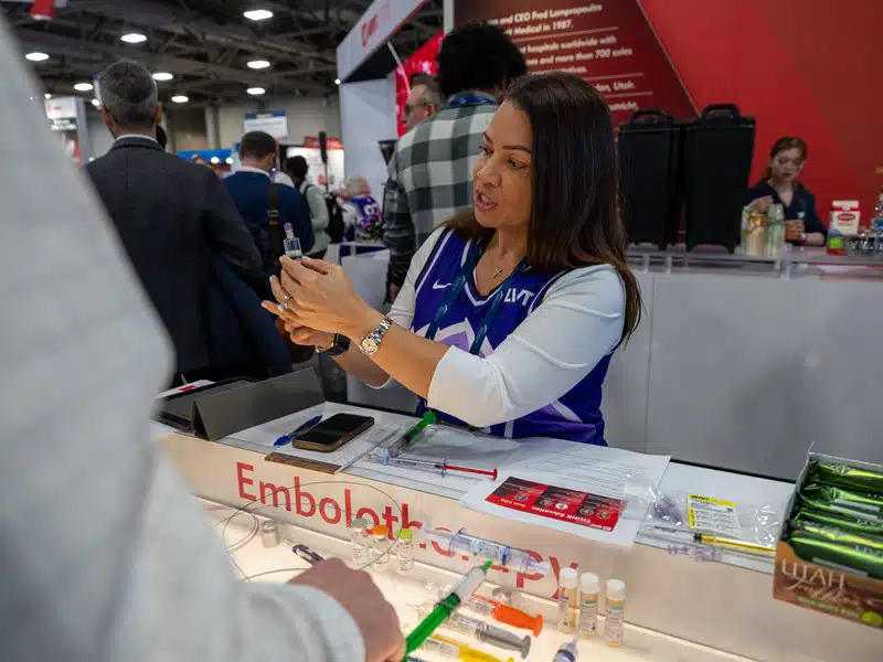 Kathy Morales demonstrating embolic products at the Merit Medical booth at SIR 2024